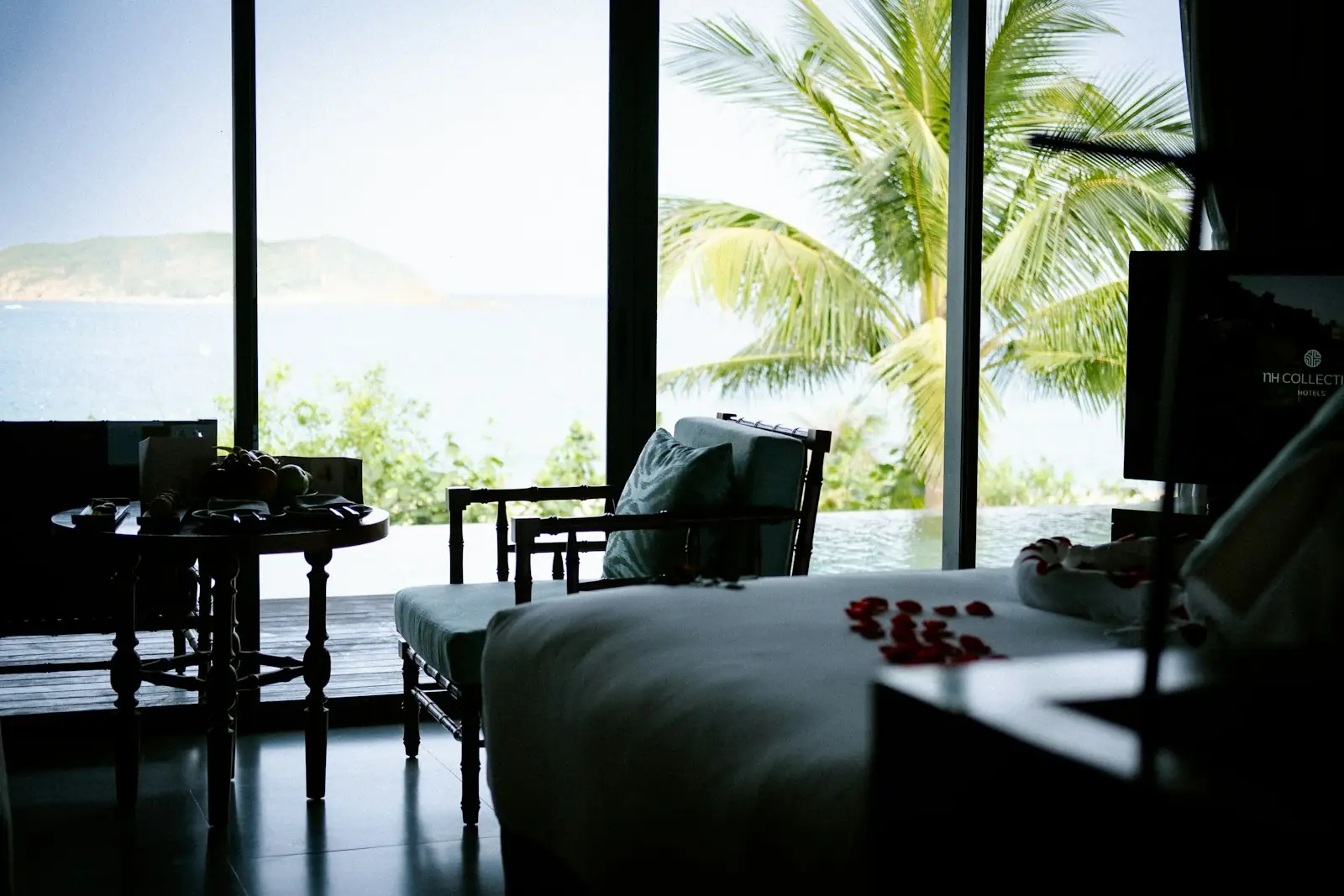 A calm bedroom with a large window onto the sea